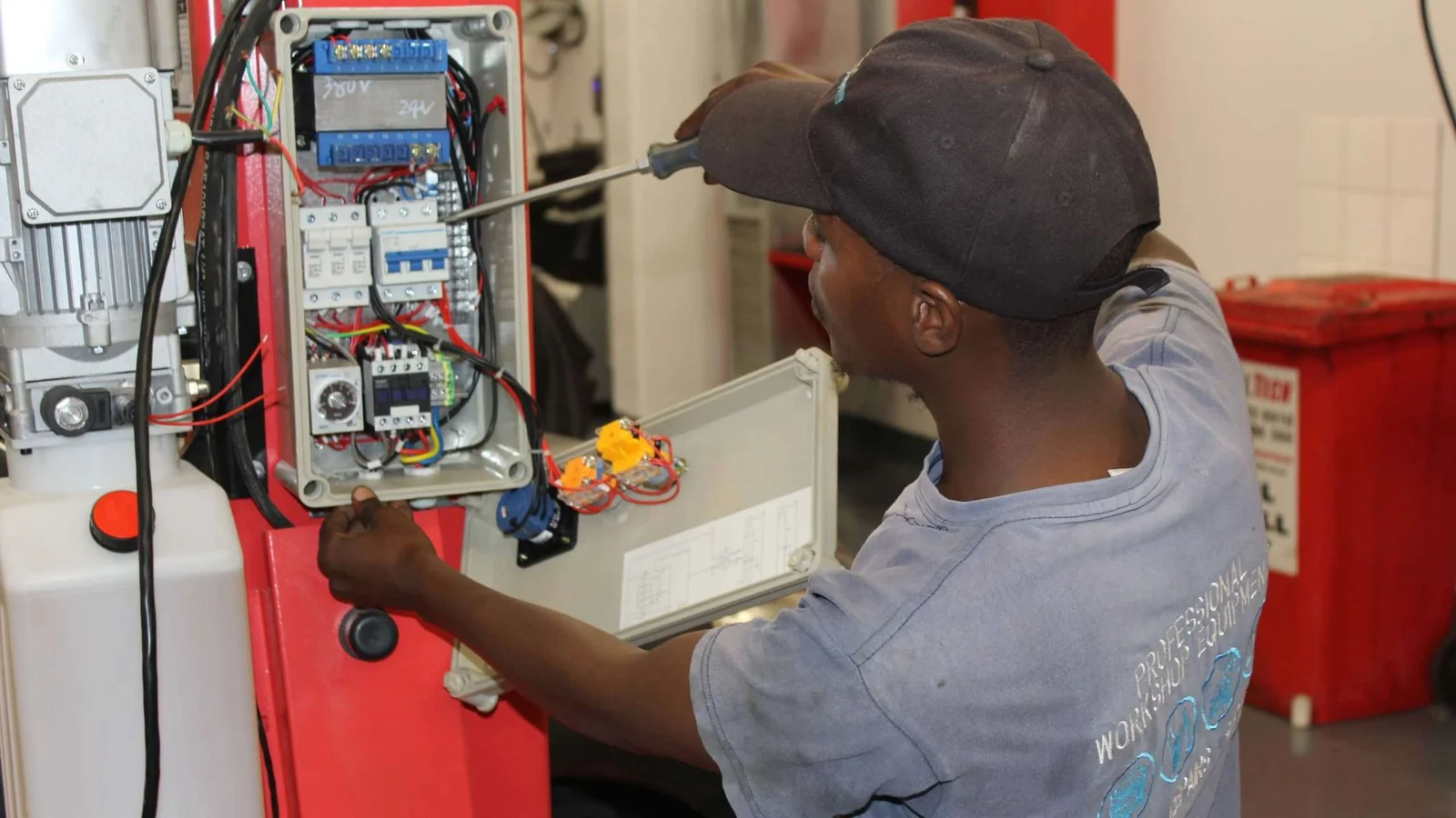 Technician commissioning the electrical supply on a newly installed vehicle lift